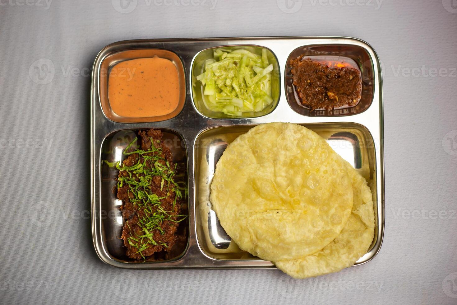 carne de vaca chaap con lucchi con Chuntney, salsa y chile inmersión servido en thali plato aislado en antecedentes parte superior ver de bangladeshi comida conjunto menú foto