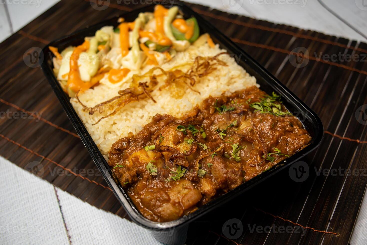Chicken Bhuna with pulao biryani rice with cucumber, dip sauce and lemon slice served in dish isolated on wooden table side view of bangladeshi and indian spicy lunch food photo