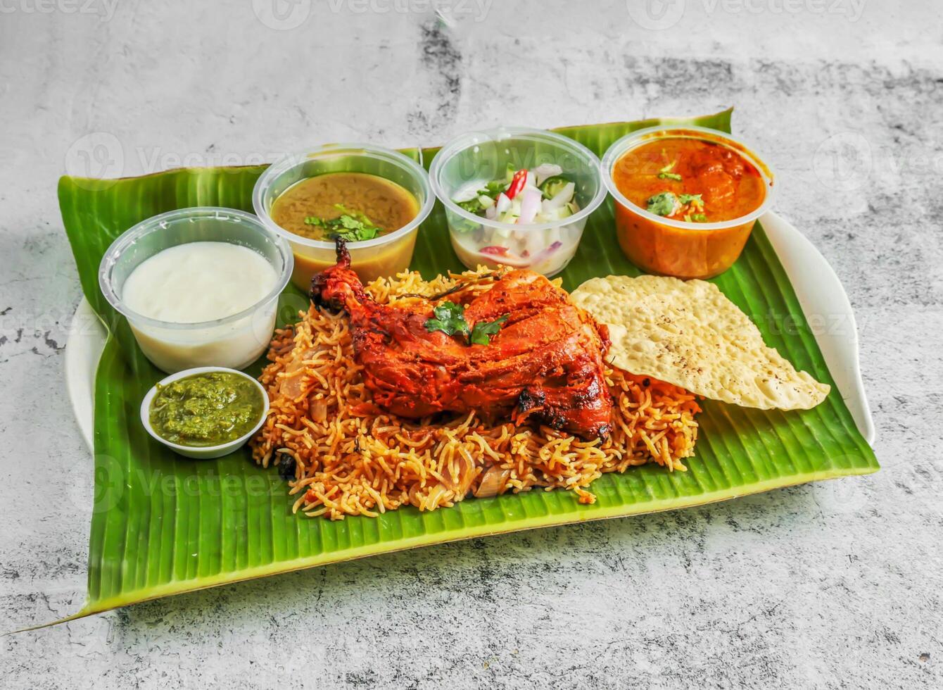 tandoori pollo briyani con ensalada, chatney, raita y salsa servido en plato aislado en plátano hoja parte superior ver de indio y Singapur picante comida foto