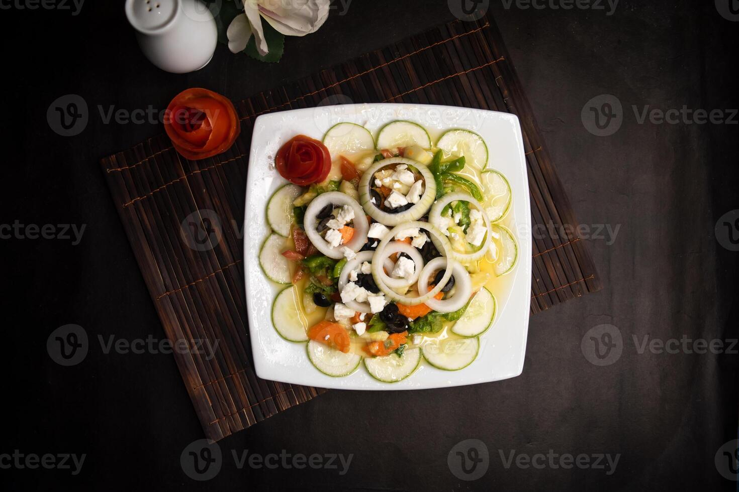 classic Greece salad with cucumber, onion, tomato, olive, carrot and feta cheese served in dish isolated on napkin mat top view of healthy supper food photo