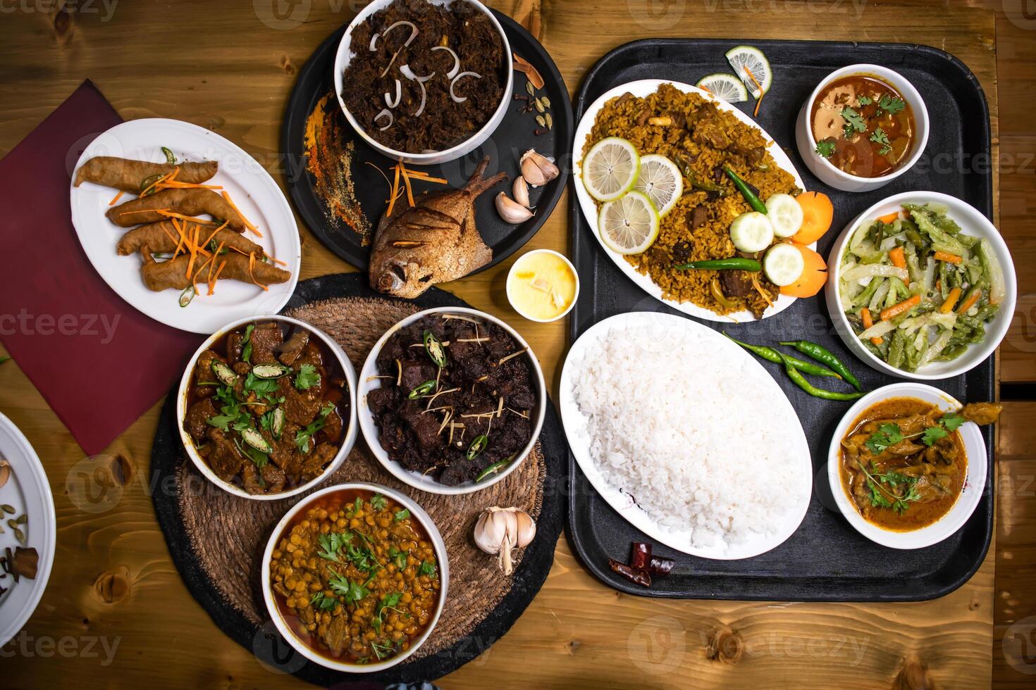 Assorted indian food Loitta Fry Fish, Fried Pomfret, Jhura Bhuna, Indian Shredded Beef, kala bhuna, mezbani Gosht, dala chana, yakhni biryani, plain rice, chicken rezala, stir fry Mix Vegetables, photo