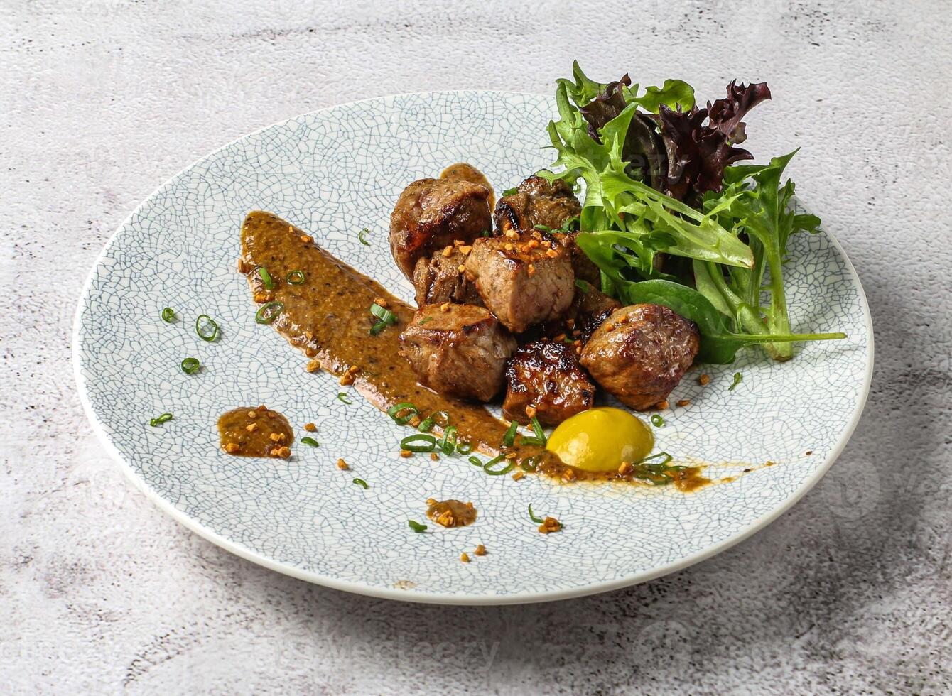 chaota grilled beef cubes tikka boti kabab with lemon and green leaves served in dish isolated on grey background top view of singapore food photo