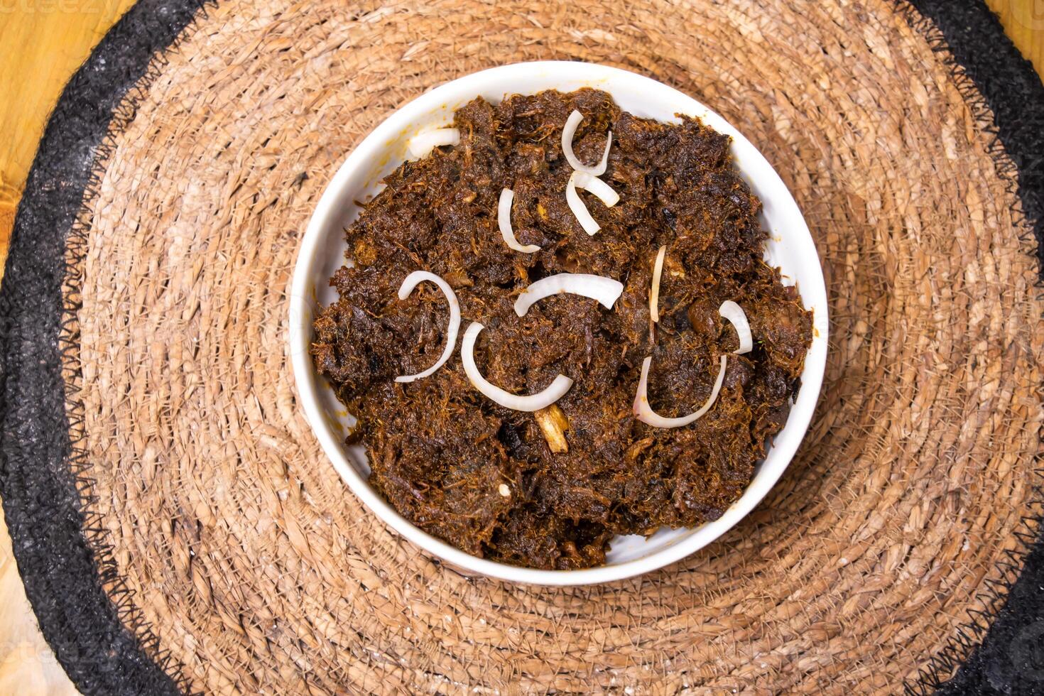 Indian SHREDDED BEEF Jhura Gosht Bhuna served in dish isolated on wooden background top view indian spices, bangladeshi and pakistani food photo