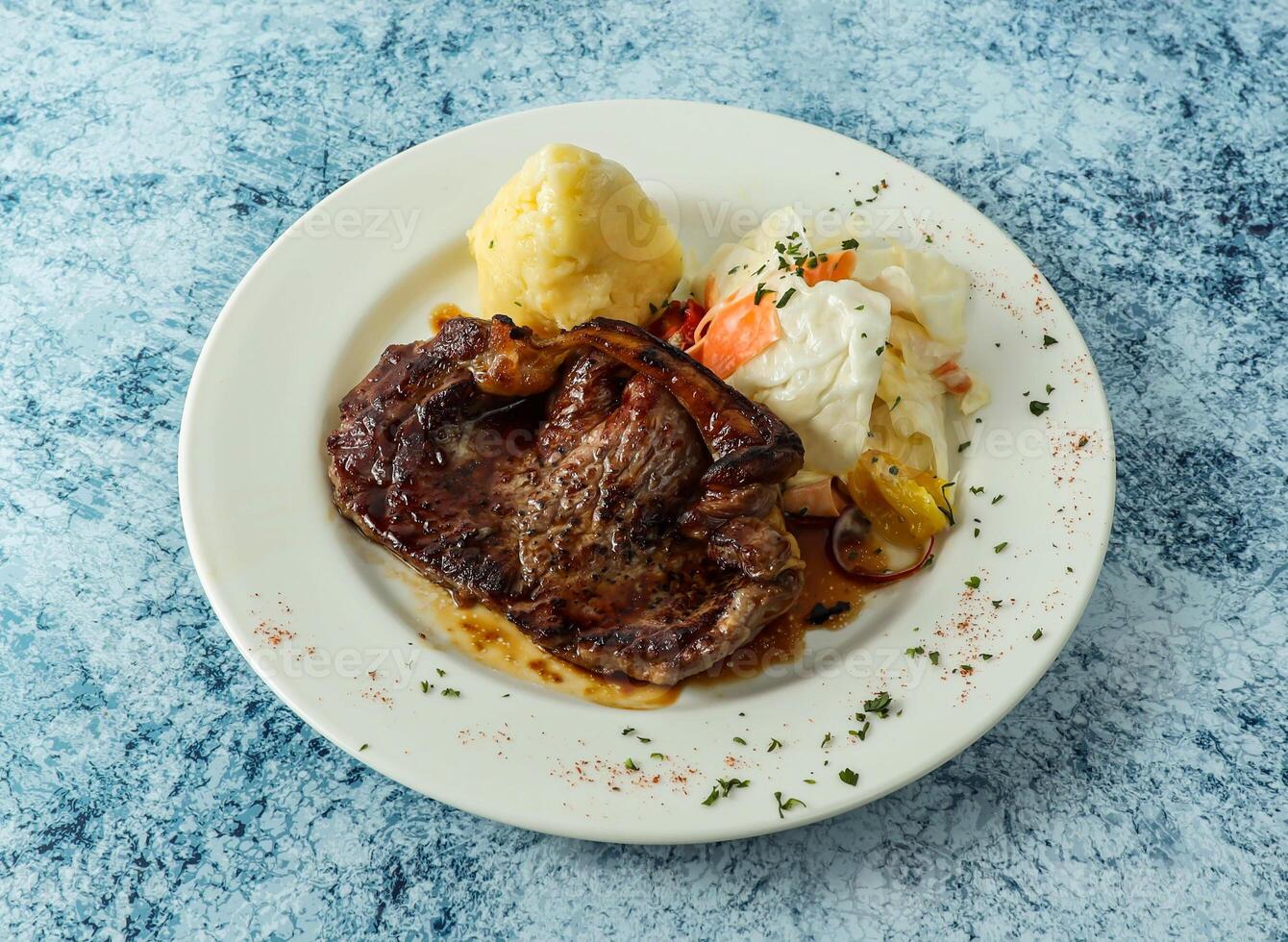 grilled beef steak with mashed potato and egg served in plate isolated on background top view of italian food photo