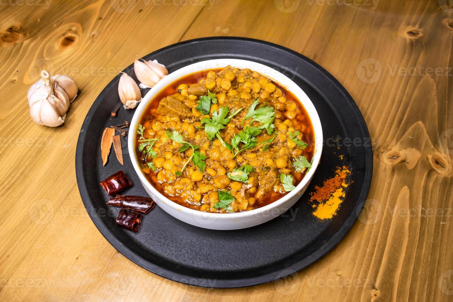 dal chana and mezbani gosht served in dish isolated on wooden background top view indian spices, bangladeshi and pakistani food photo