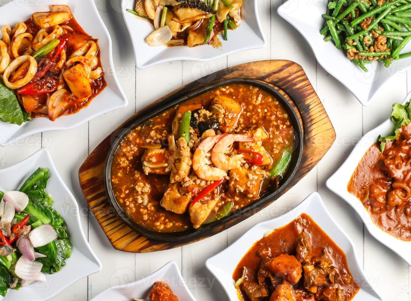 hot plate beancurd shrimp, dried shrimp fried french beans, ginger onion fish fillet, baby kailan or kai lan, sambal sotong, curry chicken, curry lamb ribs isolated on table top view of singapore food photo