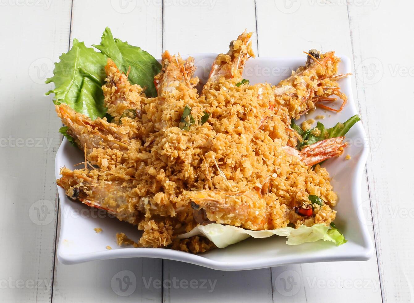 Deep fried cereal prawn served in dish isolated on table top view of singapore food photo