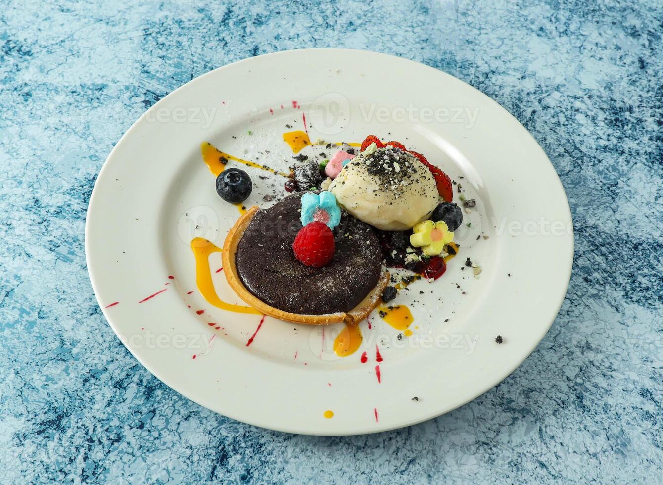 baked chocolate tart topping with strawberry and blackberry served in plate isolated on background top view of italian food photo