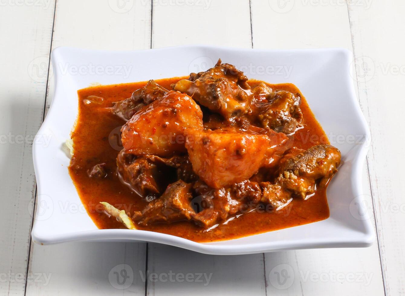 curry lamb ribs with potato served in dish isolated on table top view of singapore food photo