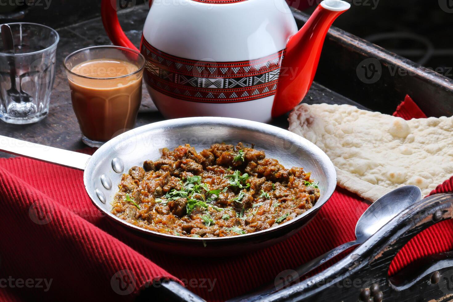 Beef Liver Masala with bread, coffee and teapot served in dish isolated on red mat top view on table arabic food photo