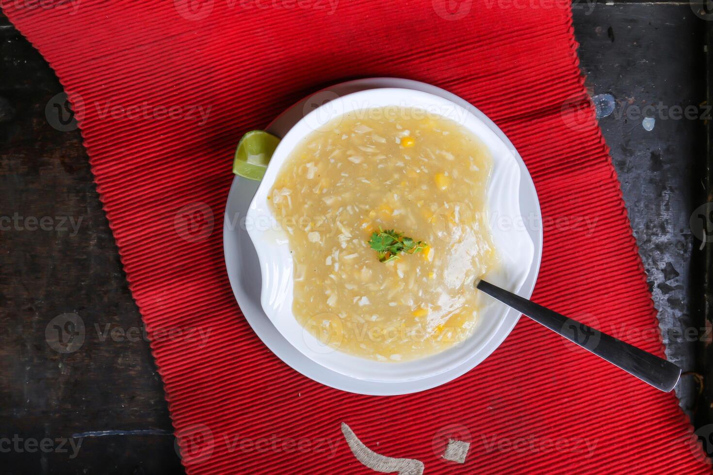 Hot Chicken Corn Soup with spoon served in dish isolated on red mat top view on table arabic food photo