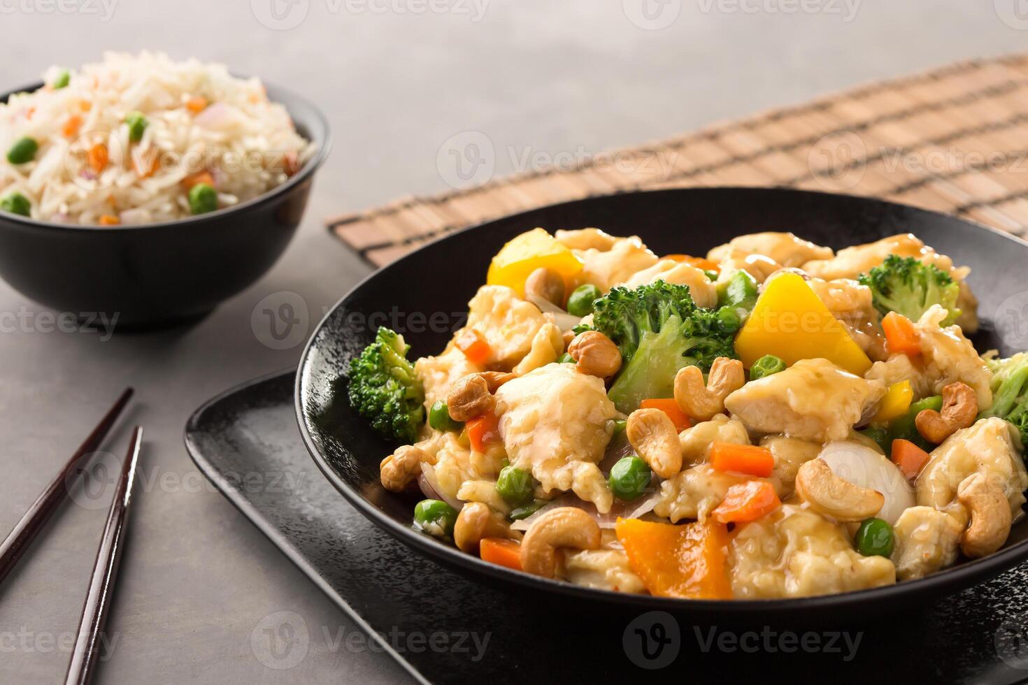 Cashew Chicken with Vegetable Fried Rice and chopsticks served in dish isolated on background top view of chinese food photo
