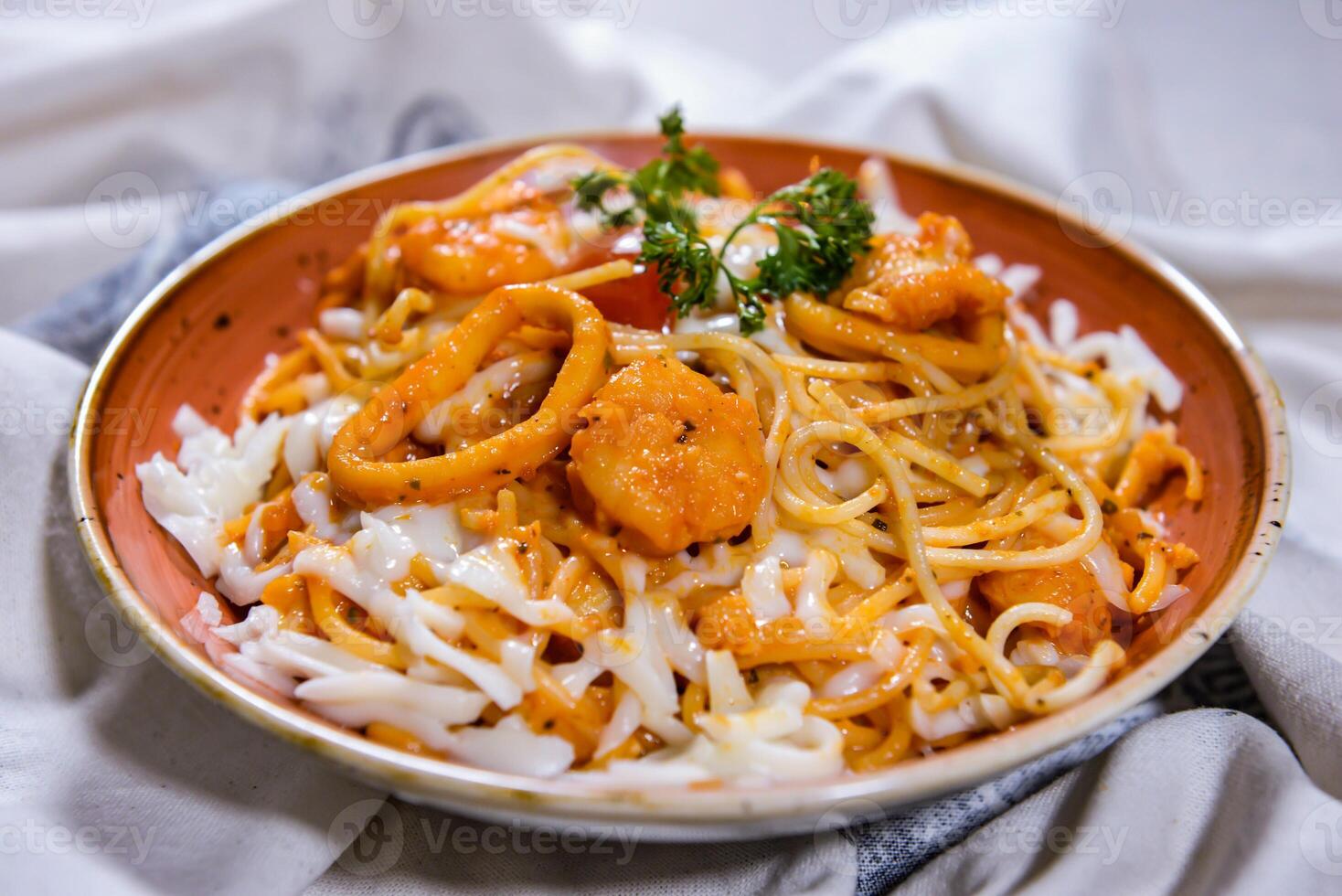 Spaghetti Marinara with noodles, seafood, squid, and fish ball served in dish isolated on food table top view of middle east spices photo