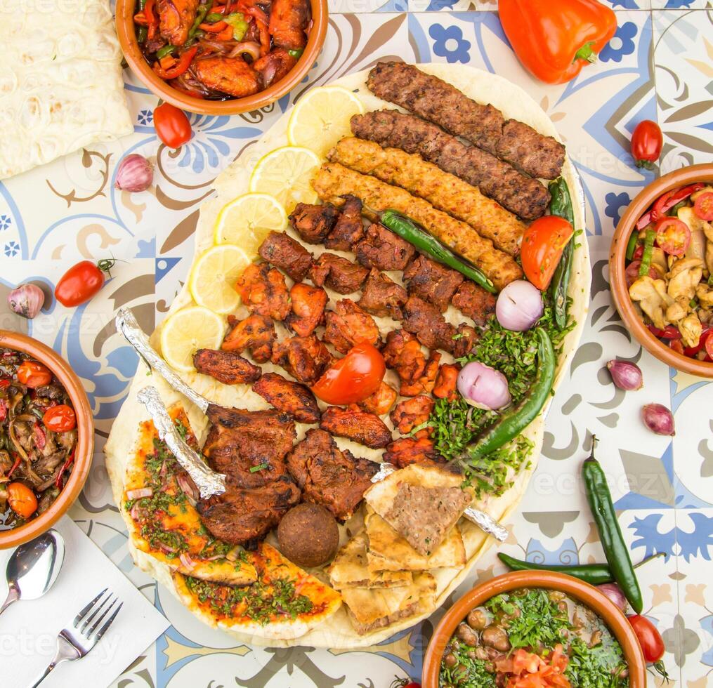 Assorted mix grills with tikka boti seekh kabab of chicken, beef, lamb chop, flafel, mutton bbq platter served in dish isolated on table top view of arabic food photo