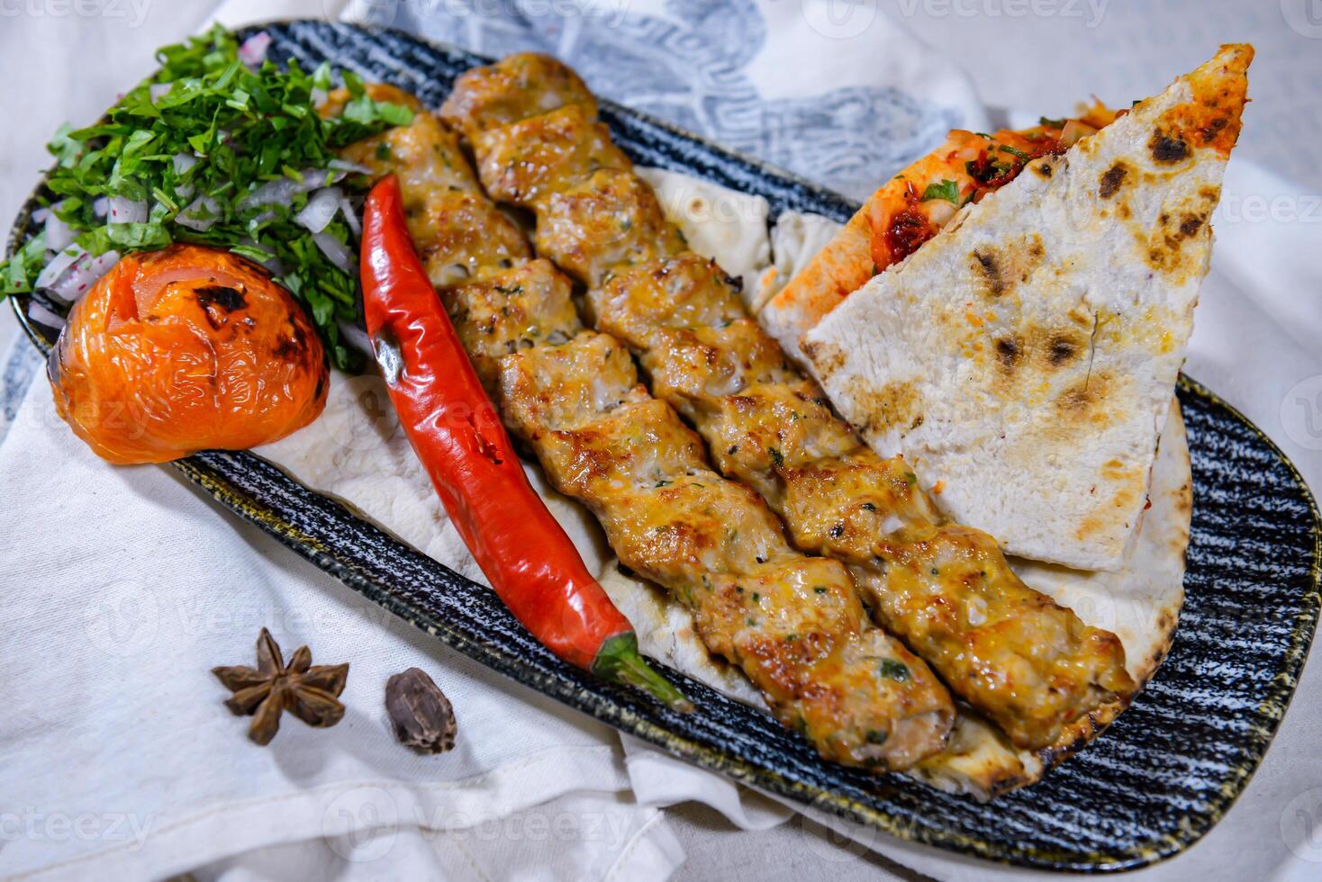 Chicken seekh kabab meat kebab with pita bread, tomato and onion served in dish isolated on food table top view of middle east spices photo