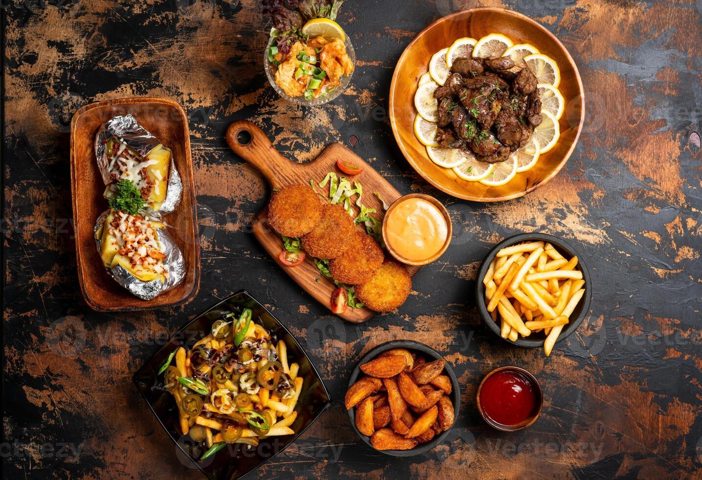 Junk fast food platter with beef liver, chicken shami kabab, veggies fries, loaded french fries, fried prawn, shawarma wrap, mayo dip and ketchup served on table top view fried food photo