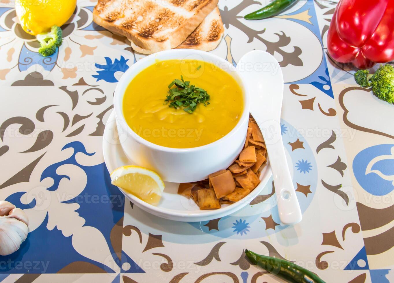 lenteja sopa con Lima, galleta, cuchara y un pan servido en maceta aislado en mesa parte superior ver de Arábica comida foto