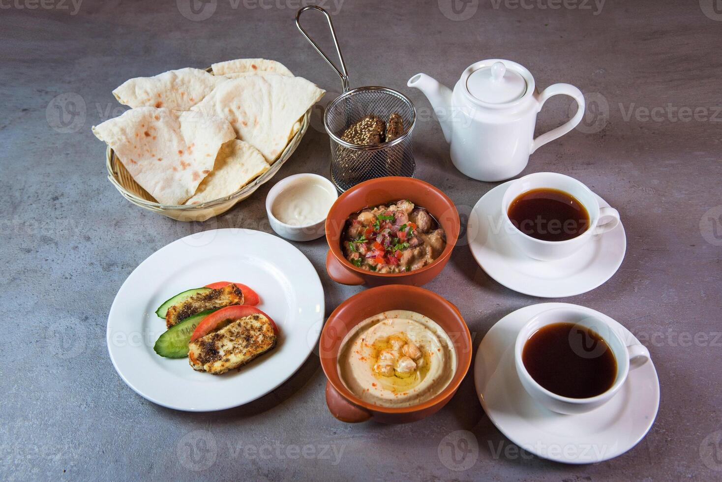 Bahrain Breakfast with hummus, beans, bread, coffee served in dish isolated on grey background top view of bahrain food photo