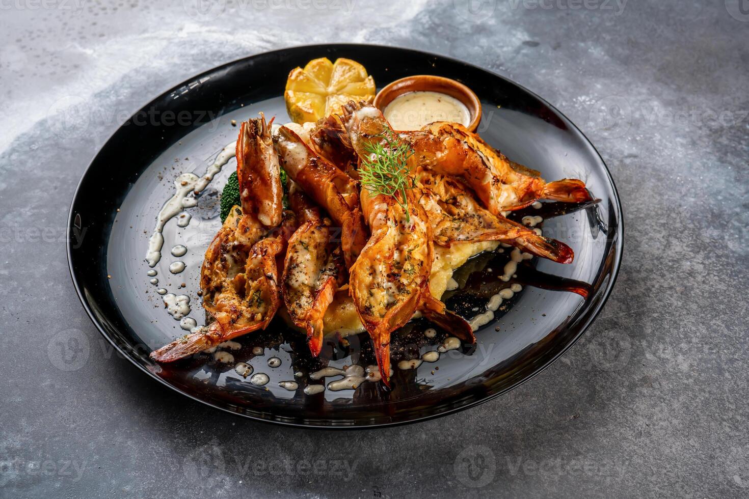 Grilled prawns with dip and lemon slice served in dish isolated on background top view of seafood grill photo