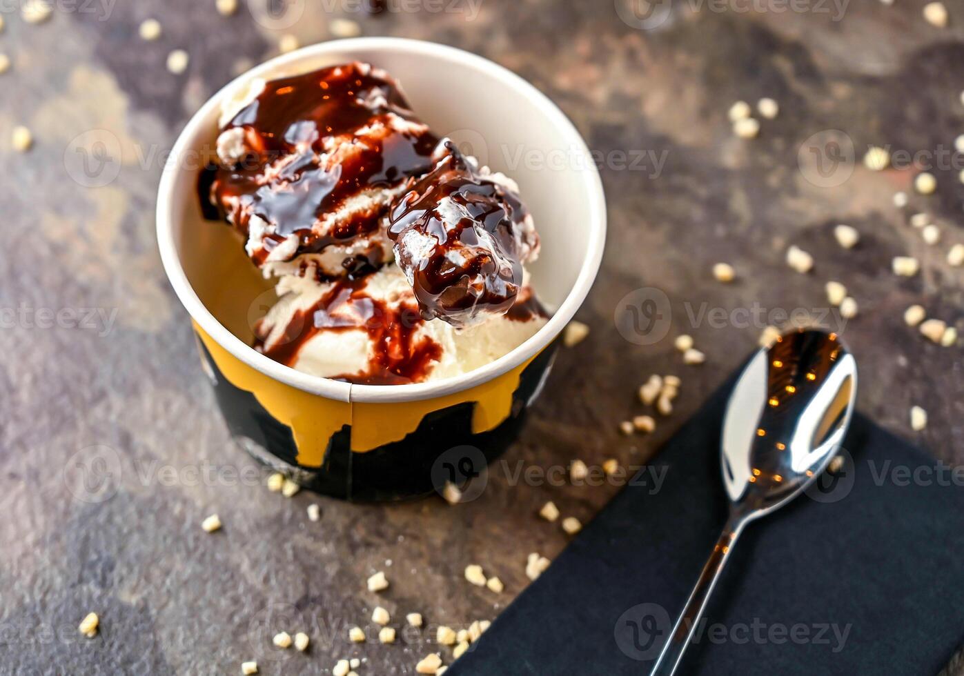 generosidad hielo crema, blanco chocolate chip, y cuchara servido en taza aislado en oscuro antecedentes de cerca lado ver de café horneado postre comida foto