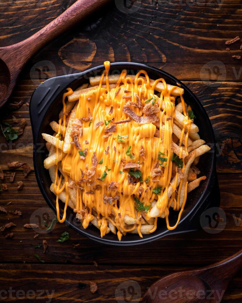 Loaded Chilli Cheese Fries served in dish isolated on wooden table top view of arabic food photo