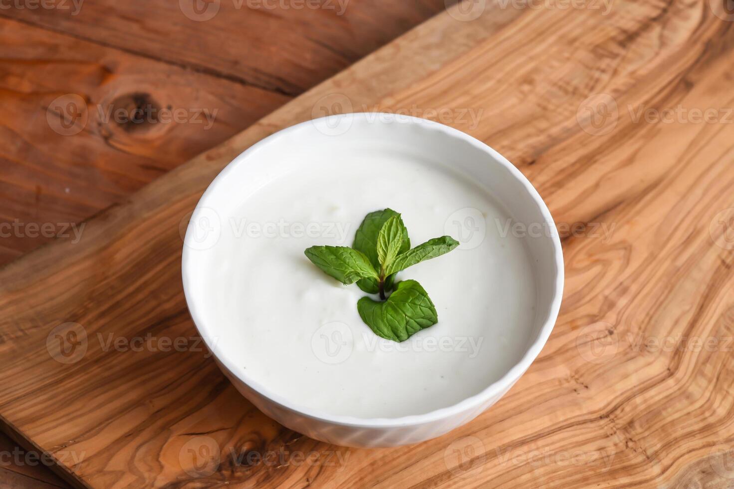 Cucumber And Mint yogurt raita served in dish isolated on wooden table top view middle eastern appetizers food photo