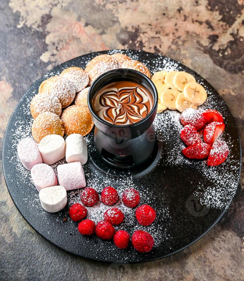 Assorted Chocolate shots with strawberry, raspberry and banana served in dish isolated on dark background top view of cafe dessert food photo