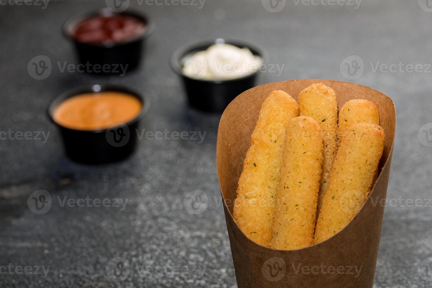 Crispy Mozzarella Cheese Sticks with dip sauce isolated on dark grey background side view of fast food sandwich photo