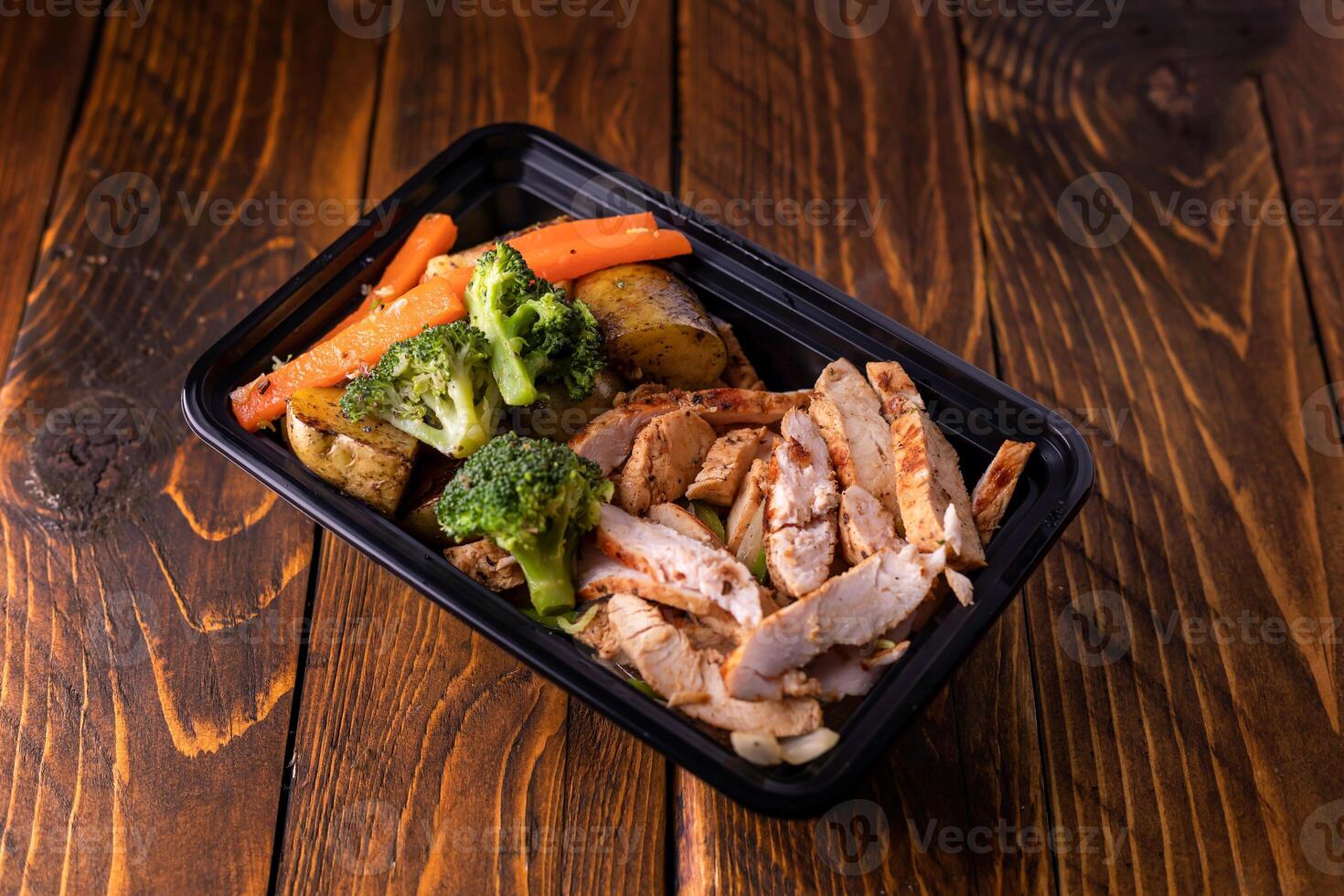 grill chicken slice with potato, broccoli and carrot served in dish isolated on wooden table side view of arabic food photo