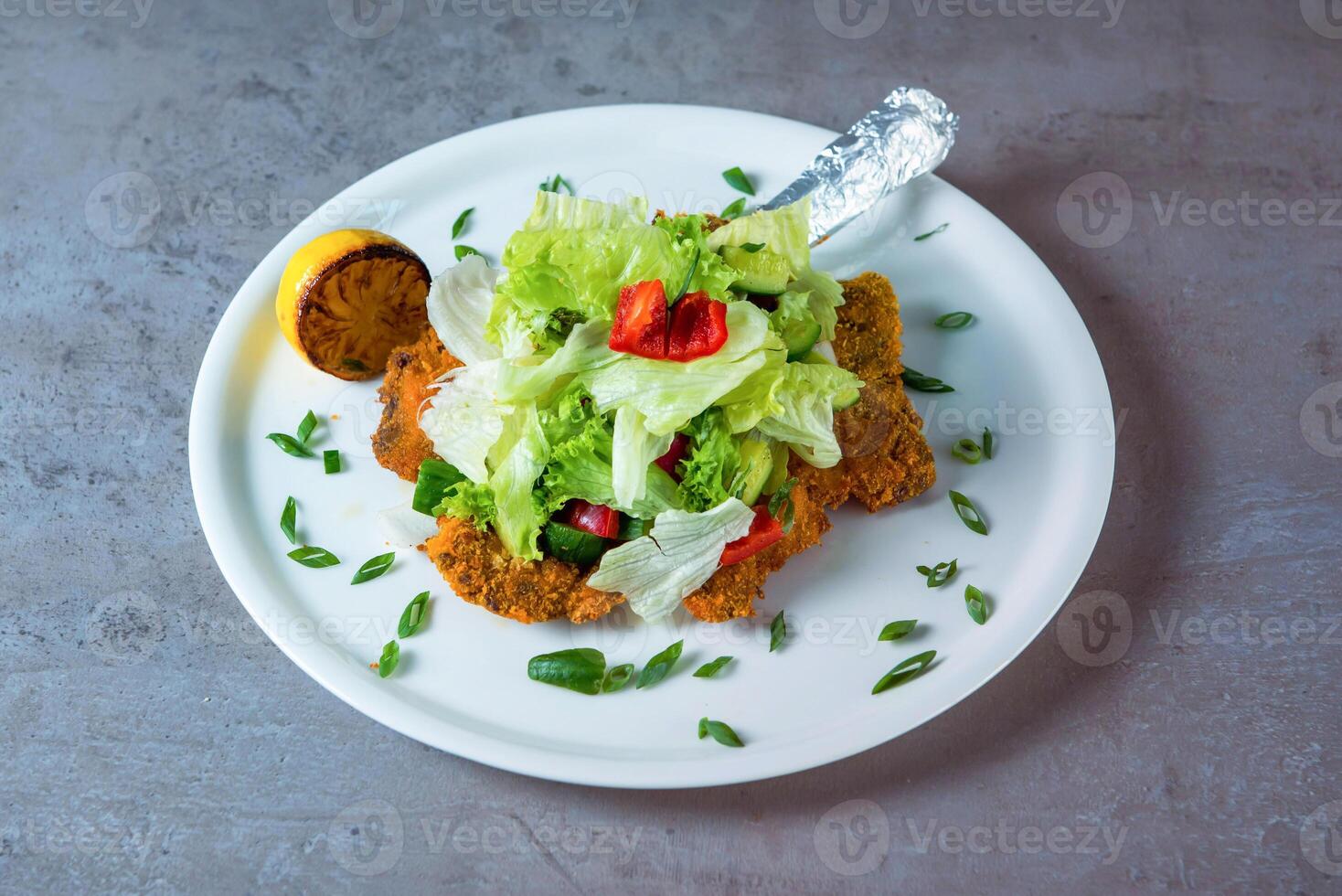 Veal Milanese with salad served in dish isolated on grey background top view of bahrain food photo