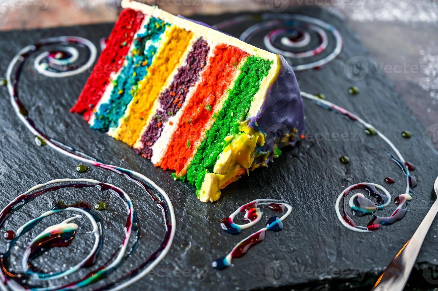 Rainbow Cake isolated on dark board side view of baked dessert cafe food photo