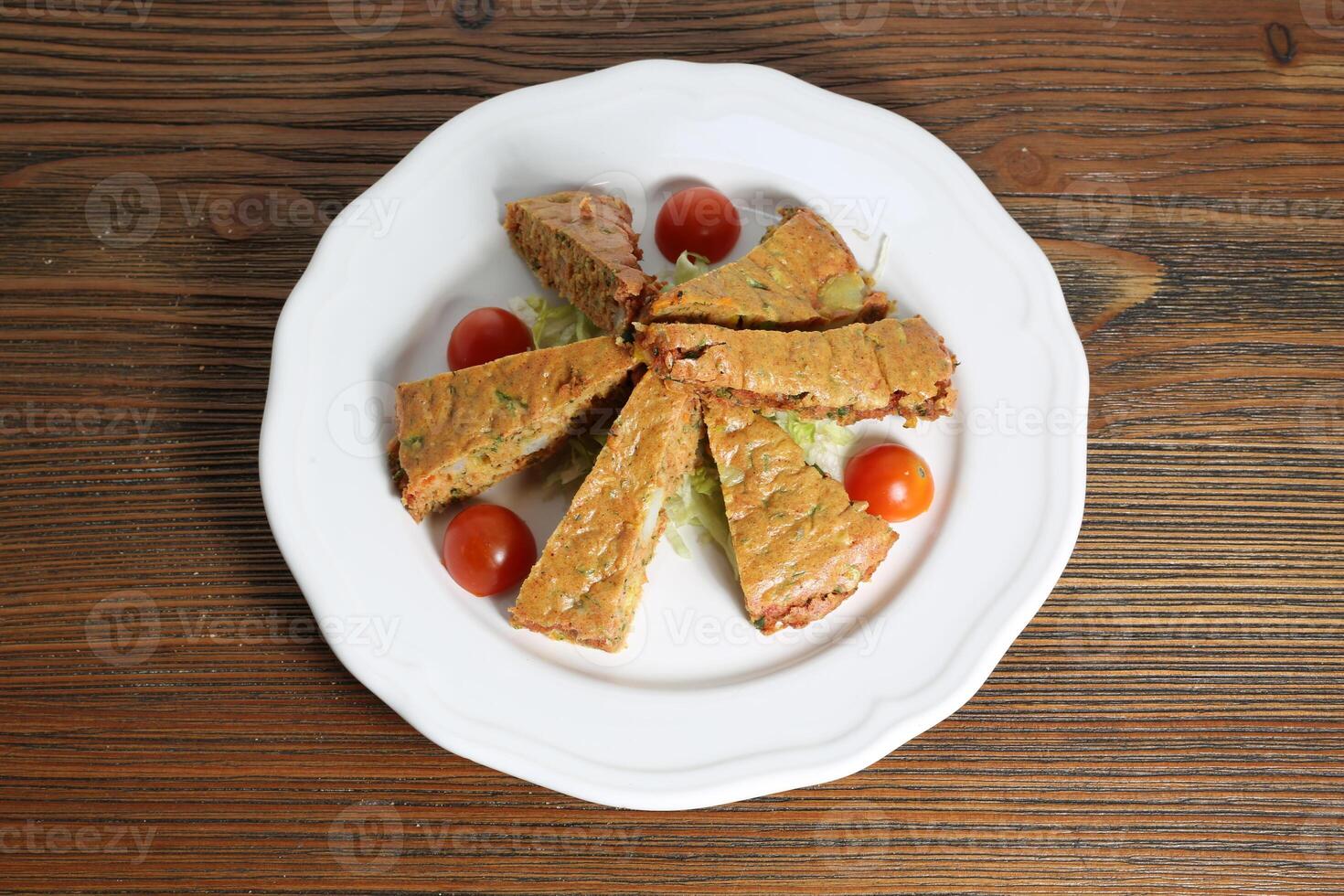 Egg omelette or omelet with cabbage and tomato served in dish isolated on table top view of arabic food photo