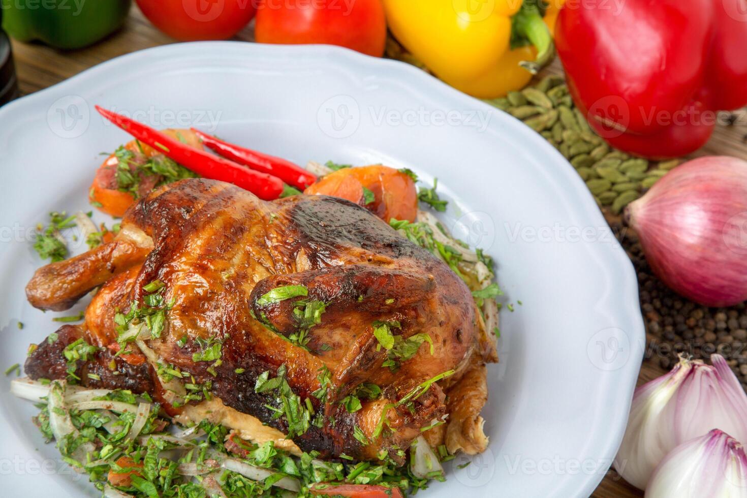 full grilled chicken with bell pepper, tomato, onion, black pepper and cardamom served in dish isolated on table side view of arabic food photo