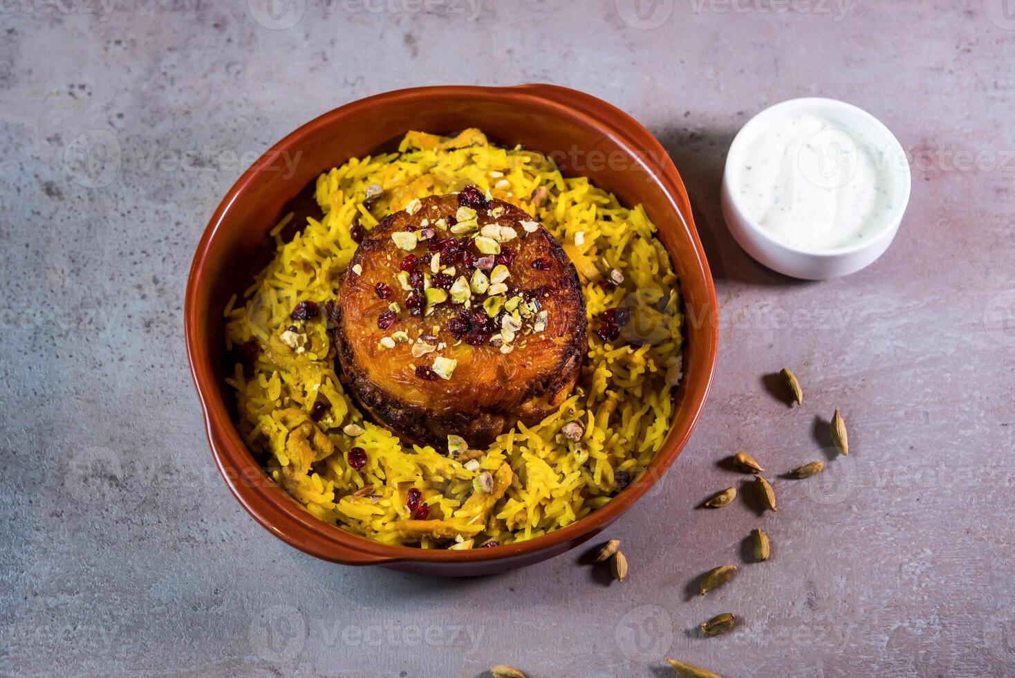 Chicken Rice Tajin or Tahjeen with nuts and mayo dip served in dish isolated on grey background top view of bahrain food photo