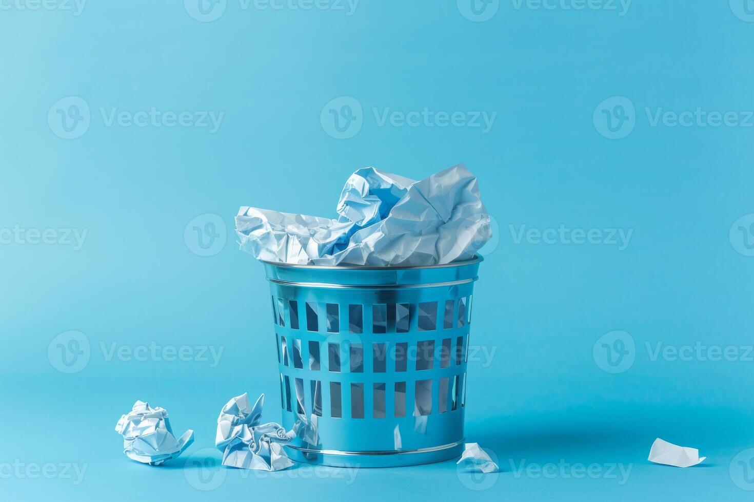 Waste basket with crumpled paper on blue background photo