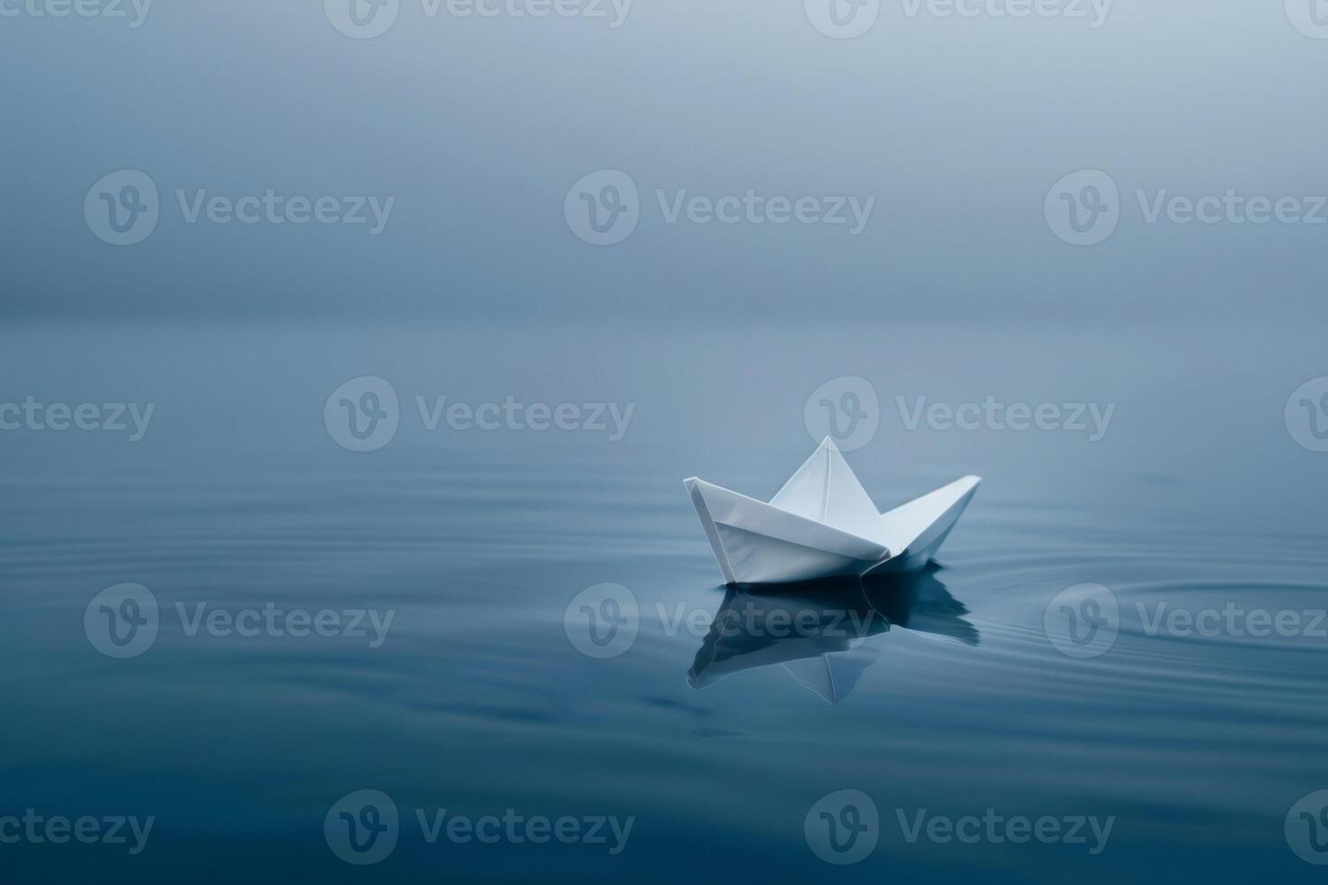 Lone paper boat sailing in ocean photo