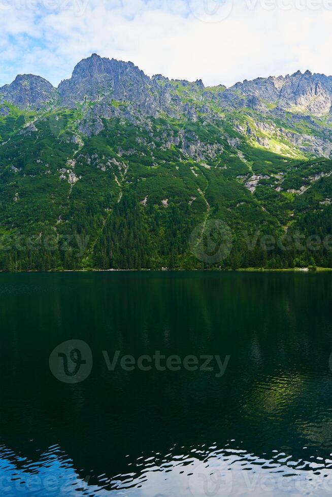 Mountains range near lake at summer day photo