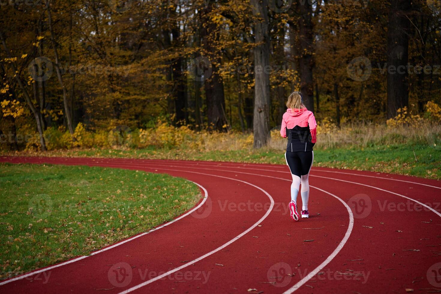 Woman running at stadium track photo