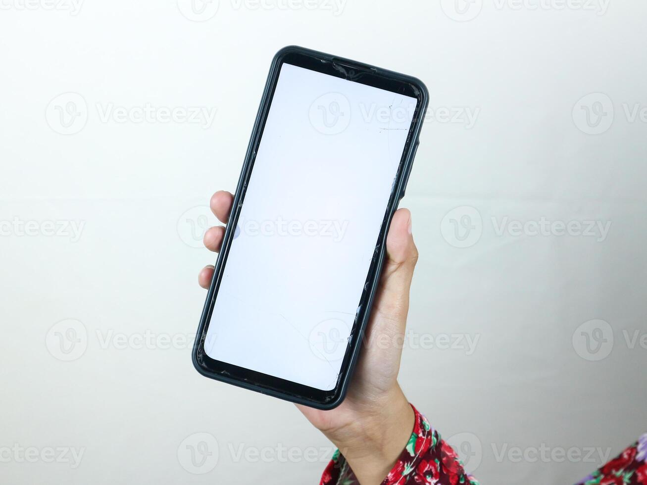 Hands of businesswoman holding smart phone with blank screen at loft office photo