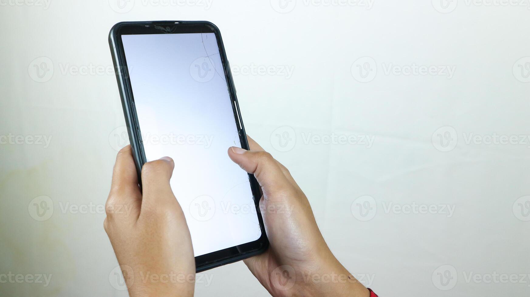 Hands of businesswoman holding smart phone with blank screen at loft office photo