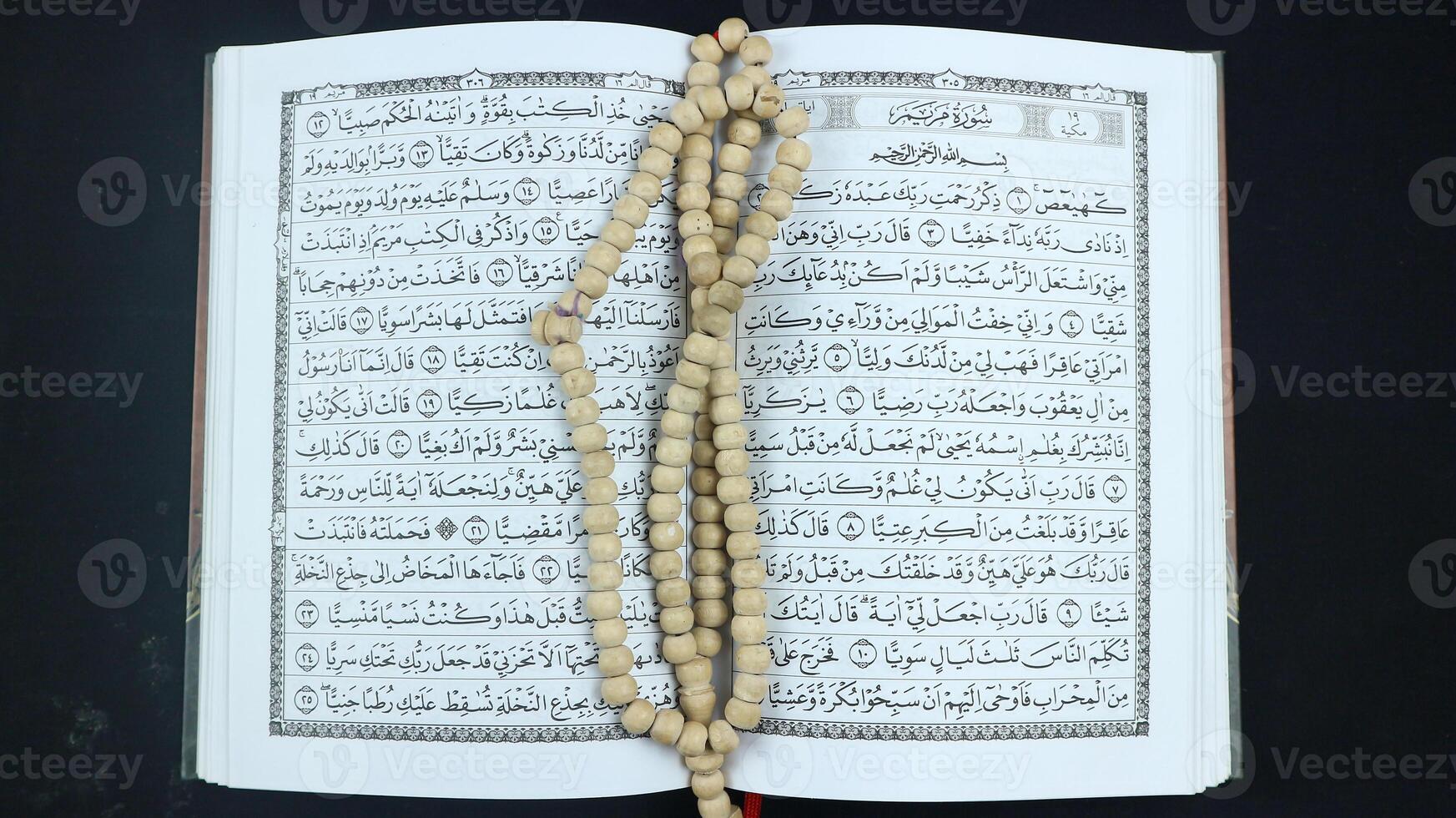 Composition with Holy Qur'an, prayer beads on black background and space for the text. photo