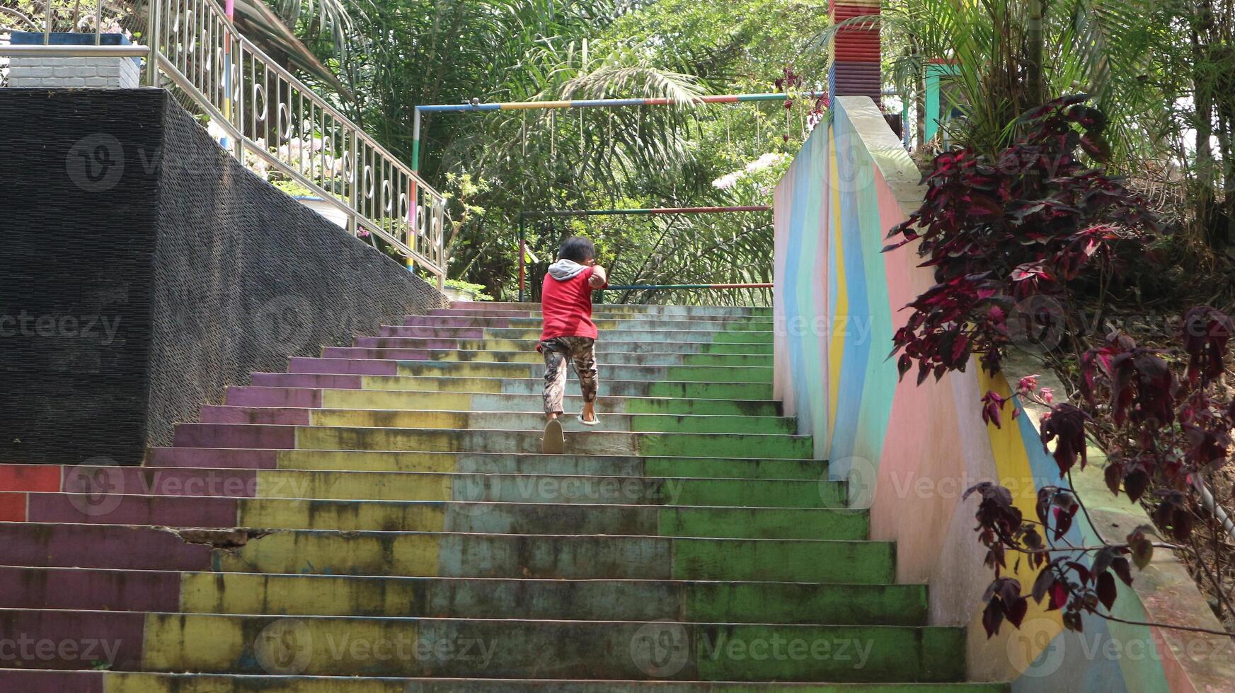 boys playing in the park, running up the colorful stairs photo