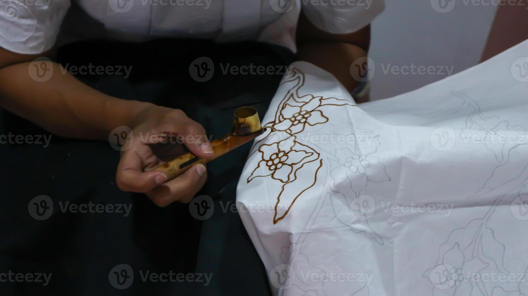 Woman hand making Indonesian batik with canting photo