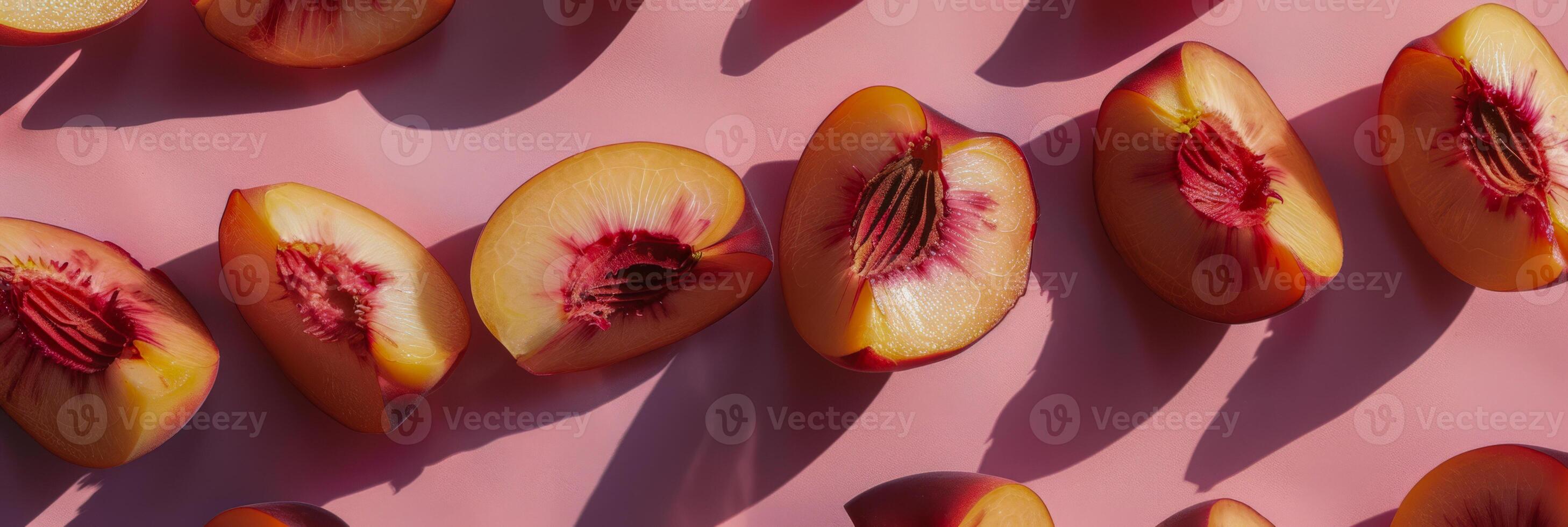 Artful Display of Peach Halves with Rich Red Centers on Pink Surface photo