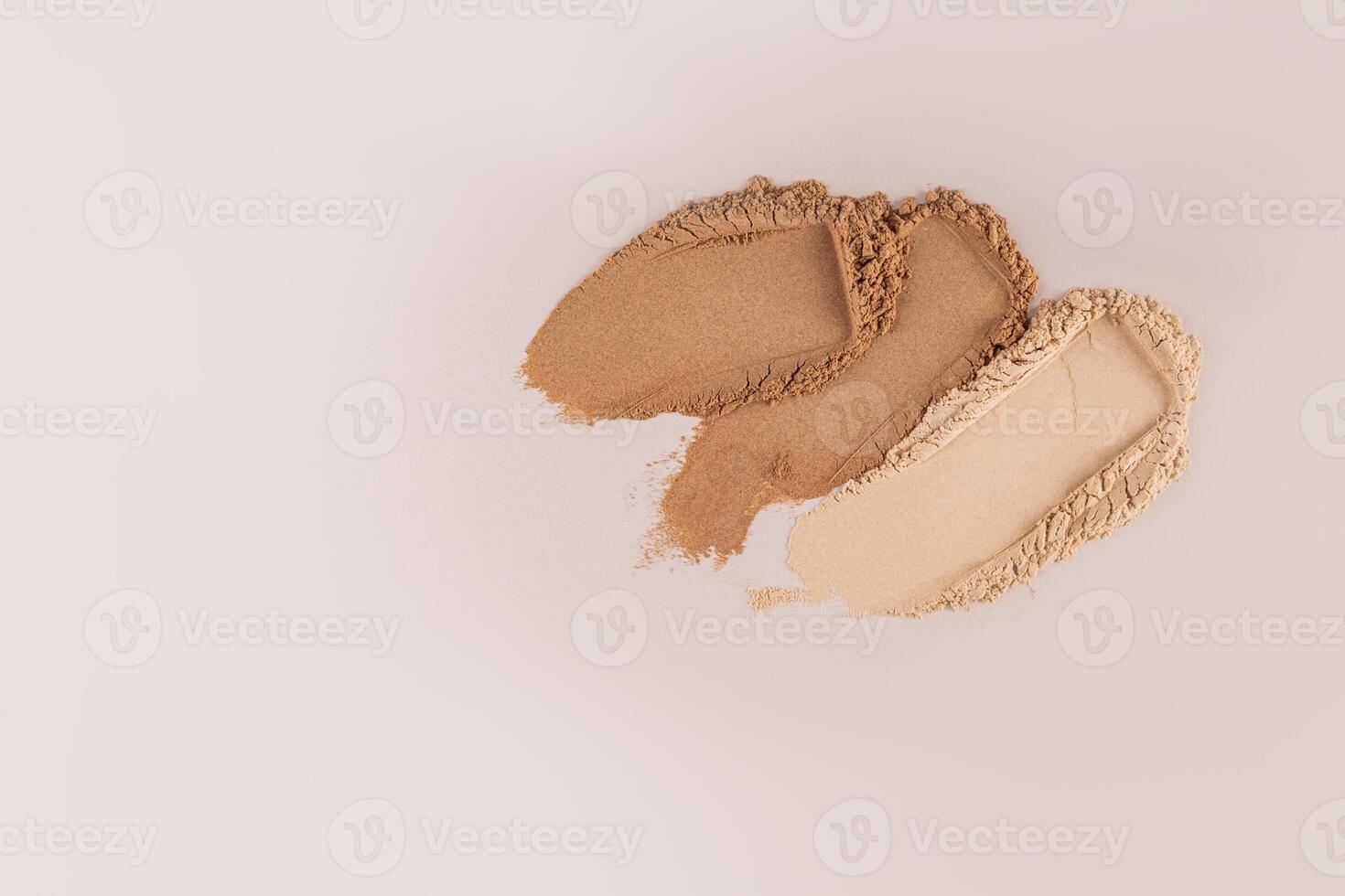 Three samples of cosmetic loose powder in classic dark and light tones on a pastel background. Top view. A copy space. Mockup for cosmetics design. photo