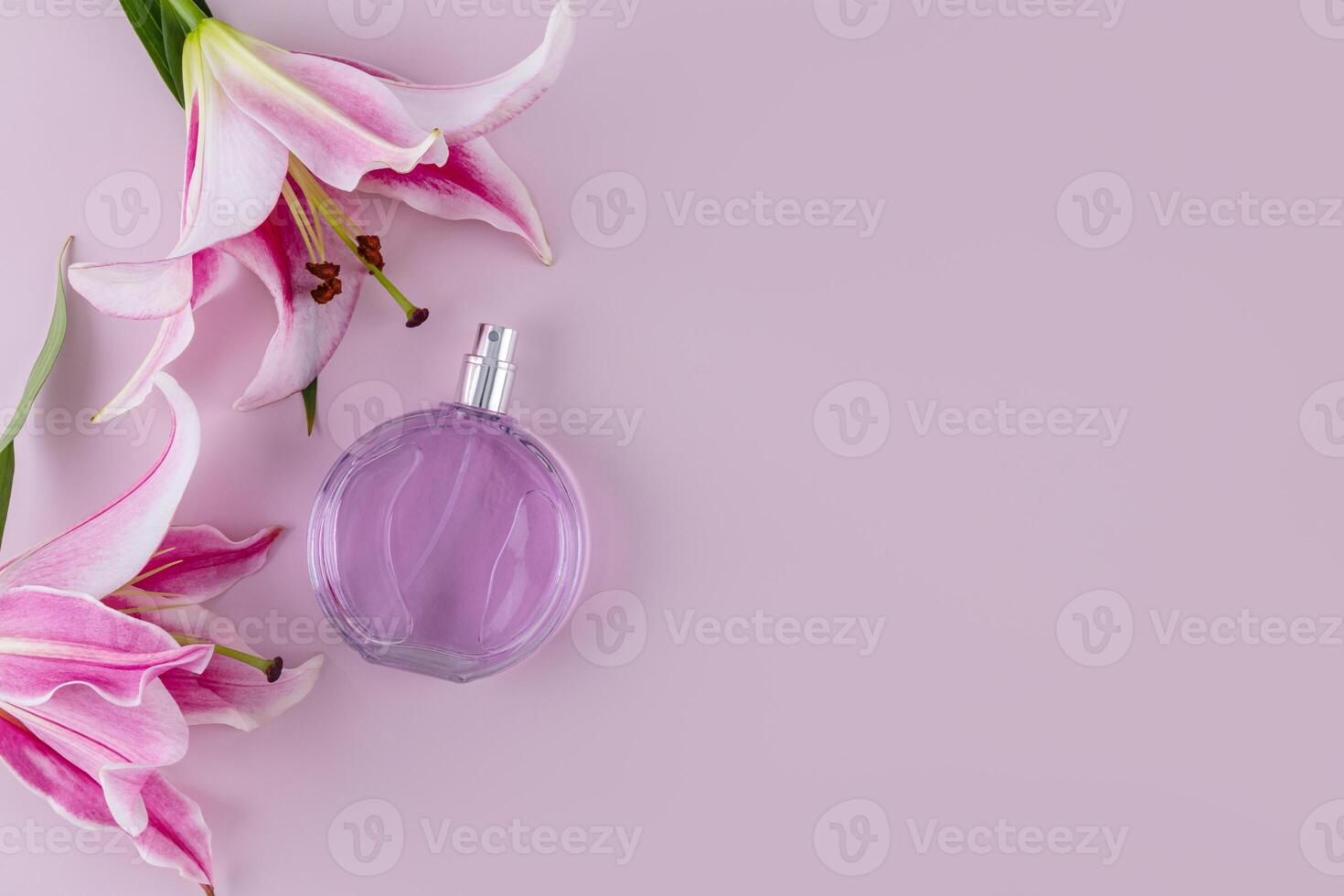 luxury round bottle of women's perfume on pastel background with garden delicate lilies. Presentation of a floral fragrance. Top view. A copy space photo