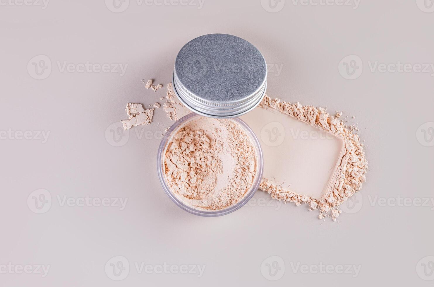 Open cosmetic jar with silver lid with delicate loose powder on pastel background with powder swatch. Top view. A copy space. photo