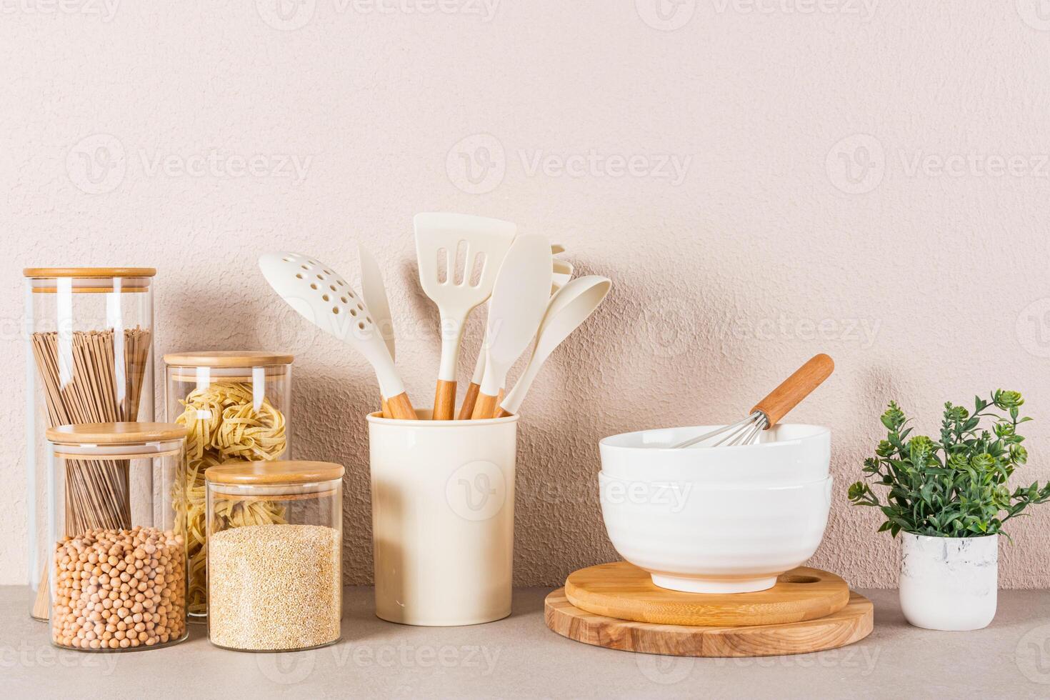 Beautiful kitchen background with bulk food storage area, spoons and cooking tools and green plant in a pot. Front view. photo
