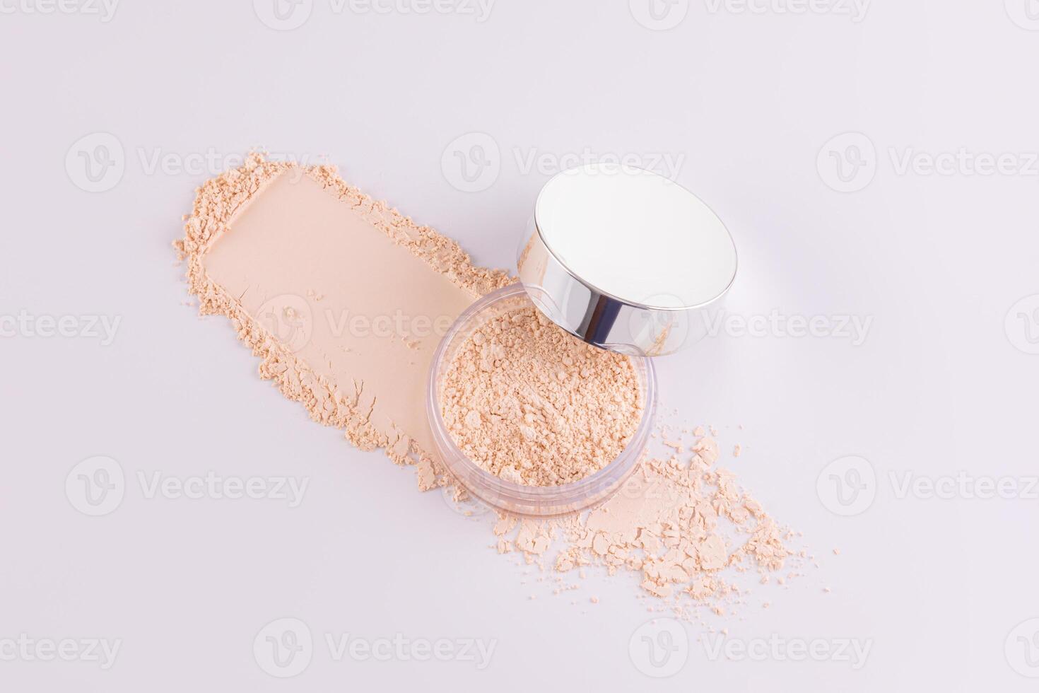 An open jar with loose powder in a natural tone and a swatch of powder on a white background. Top view. Decorative cosmetics concept. photo