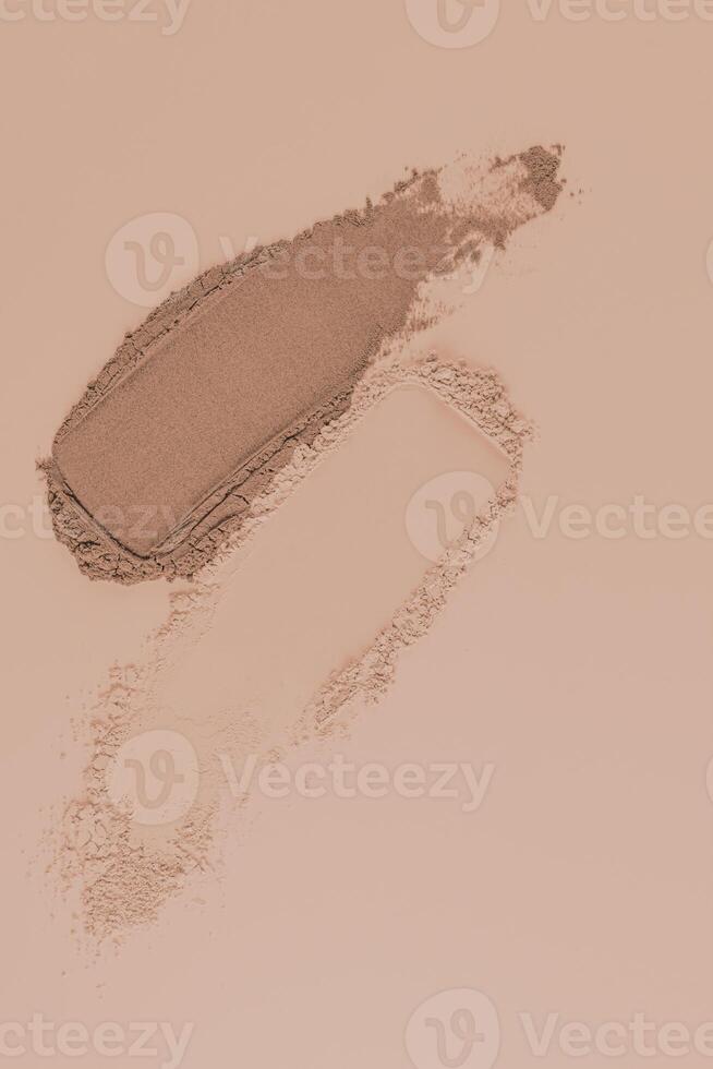 Two swatches of cosmetic structure powder powder in natural beige tone and bronze. Top view. Beige vertical background. Layout. Sample. Template. photo